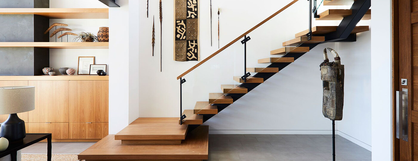 Bright interior with a floating oak staircase and open shelving